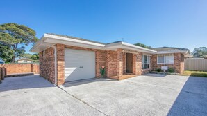 Einbungalow mit Garage, Ziegelhaus und überdachter Auffahrt.