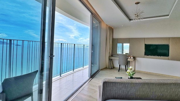 Een moderne hotelkamer met balkon, een bed, bureau en televisie.