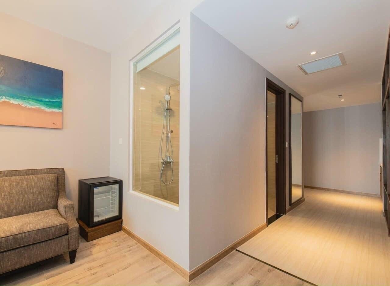 Ein modernes Wohnzimmer mit einer Couch, einer Duschkabine aus Glas und einem Bild an der Wand.