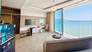 Een moderne hotelkamer met een groot balkon, een flatscreen televisie, een bureau en een bank.