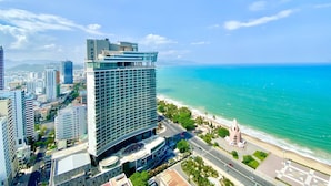 Een hoog hotel met een modern ontwerp, gelegen nabij een strand met helder turquoise water.