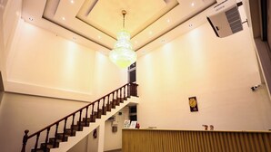 A hotel lobby with a grand staircase, a reception desk, and a chandelier. - ReeCha Mullai Resort (Iyakachchi)