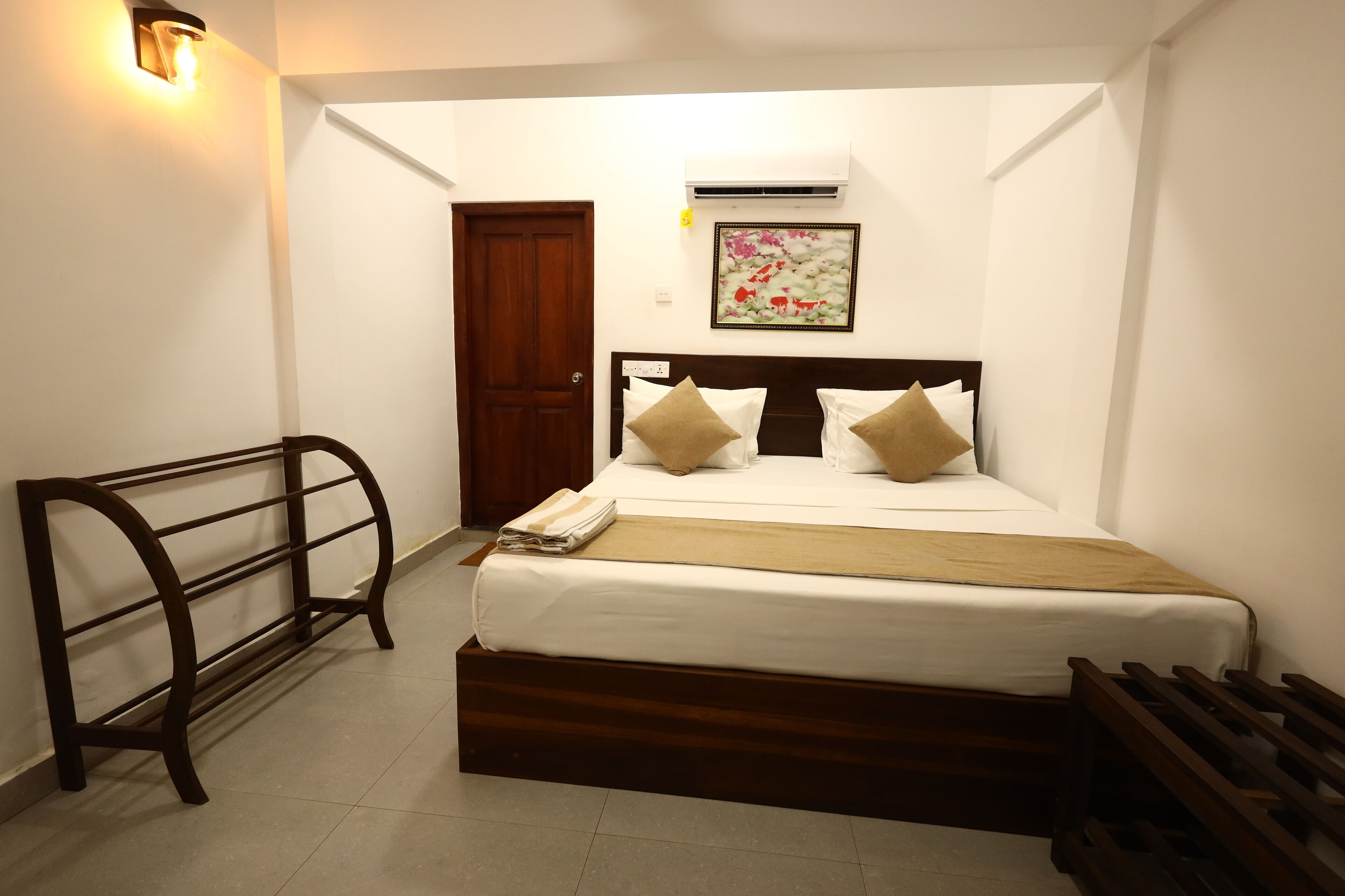A neatly arranged bedroom with a bed, a bench, and a door.