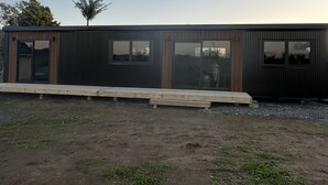 A modern building with large windows and a flat roof. - Tranquility - Rural Location (Horse Friendly) (Ohinewai)