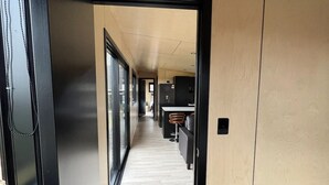 A hallway with a bed, a desk, and a kitchen area. - Tranquility - Rural Location (Horse Friendly) (Ohinewai)
