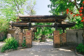 Une porte en bois traditionnelle, avec un chemin pavé qui la traverse.