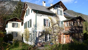Een traditionele chalet met een schuin dak, houten balkons en een stenen fundering.
