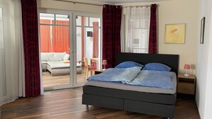 A bedroom with a bed, a nightstand, a chair, and a sliding glass door leading to a balcony. - Moderne Ferienwohnung 90qm, mit Garten in Wesernähe - Nähe Golfplatz (Achim)