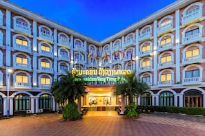 A hotel with multiple balconies, a central entrance, and flags. - Lisha roungnakhone hotel (Vang Vieng)