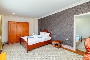 A hotel room with a wooden bed, a small bedside table, a wardrobe, and a patterned wall. - Lisha roungnakhone hotel (Vang Vieng)