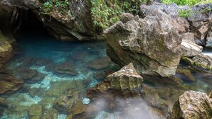 Una bassa natural de roca amb aigua cristal·lina i roques al voltant.