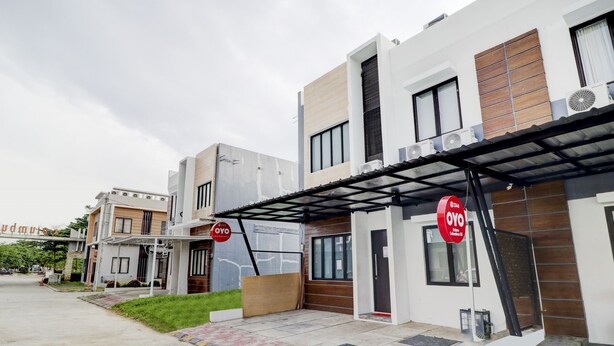 A modern building with a covered entrance, air conditioning units, and a sign for OYO hotel. - Hotel O Ada Residence (Karawang)
