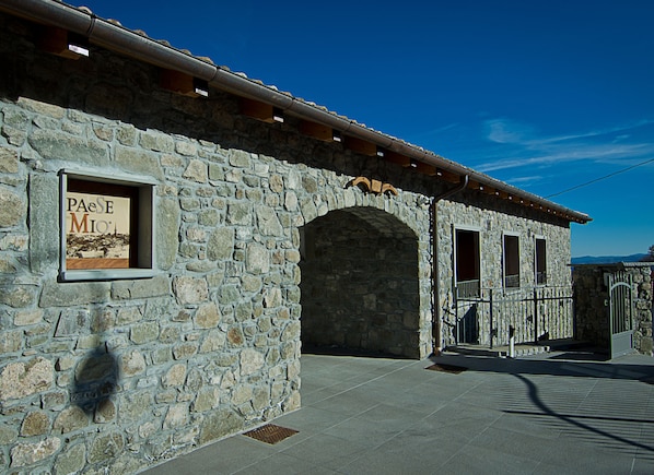 Un edificio de piedra con un letrero que dice "PaeSe Mio".