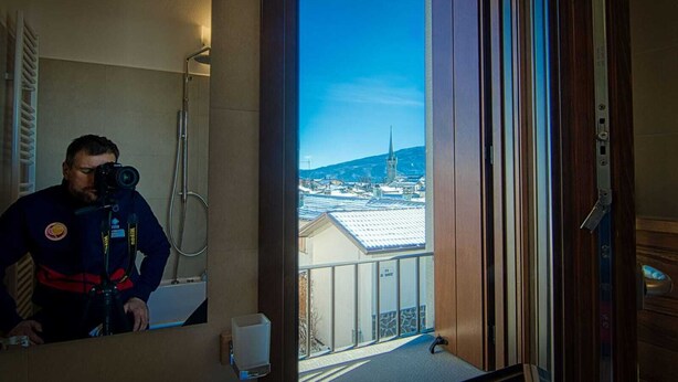 A hotel room with a balcony overlooking a snowy town and a church spire. - PAESEMIO.CERVAREZZA (Ventasso)