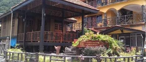A traditional wooden building with a tiled roof, a balcony, and a sign indicating a museum.