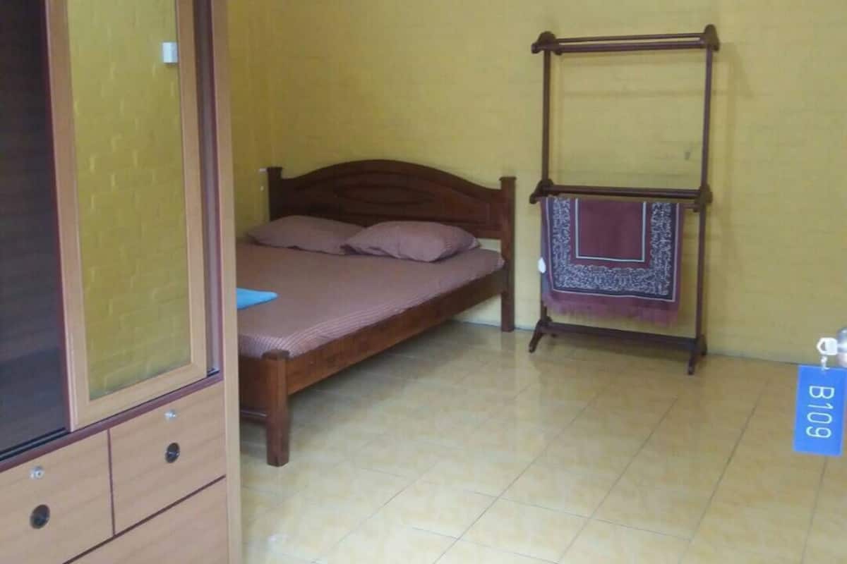 Ein Schlafzimmer mit einem Bett, einem Holzschrank und einer Hängematte.