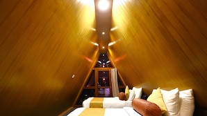 A triangular room with a bed and a window. - Reecha Kurinji Resort (Iyakachchi)