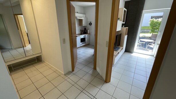 Un appartement moderne doté d’une cuisine, d’un coin repas et d’un balcon aménagé avec du mobilier d’extérieur.