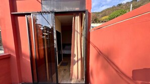A sliding glass door leading into a room with a bed and a window. - Villa Noelia Garden Suite - Coatepeque Lake (Lago de Coatepeque)