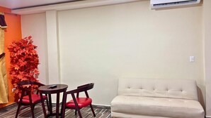 A room with a sofa, two chairs, a small table, and a decorative plant. - Villa Noelia Calli Suite - Coatepeque Lake (Lago de Coatepeque)