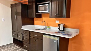 A compact kitchen with a microwave, sink, and a coffee maker on the countertop. - Villa Noelia Calli Suite - Coatepeque Lake (Lago de Coatepeque)
