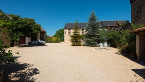 A gravel driveway leading to a house with a car parked on the left. - Maison Anjou 13 Personnes (Montreuil-Bellay)