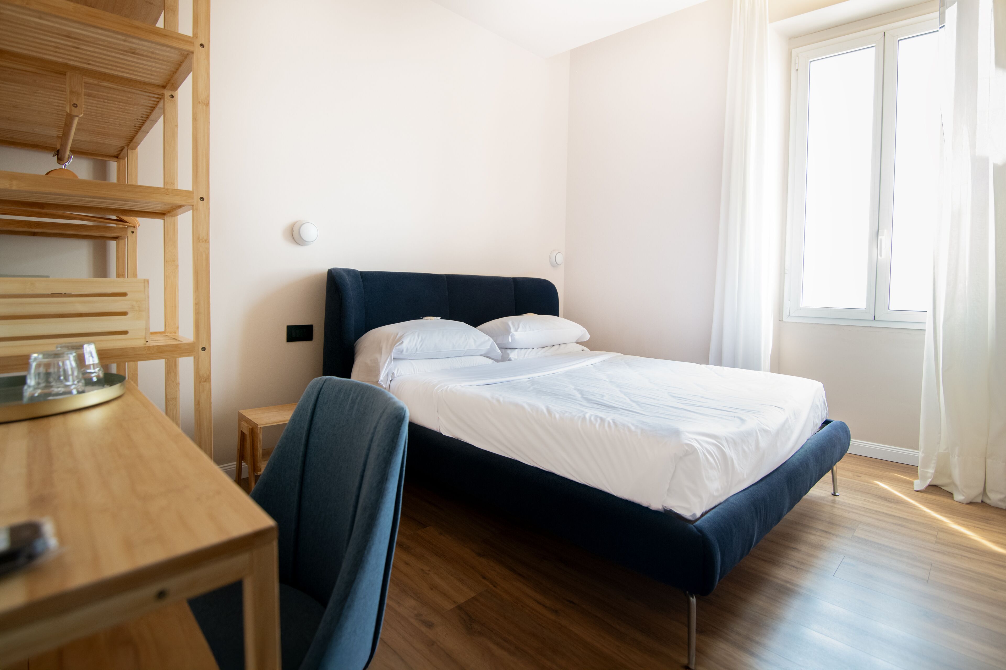 A bedroom with a bed, a desk, and a chair.