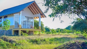 Une maison à deux étages dotée d’un balcon, entourée de verdure.