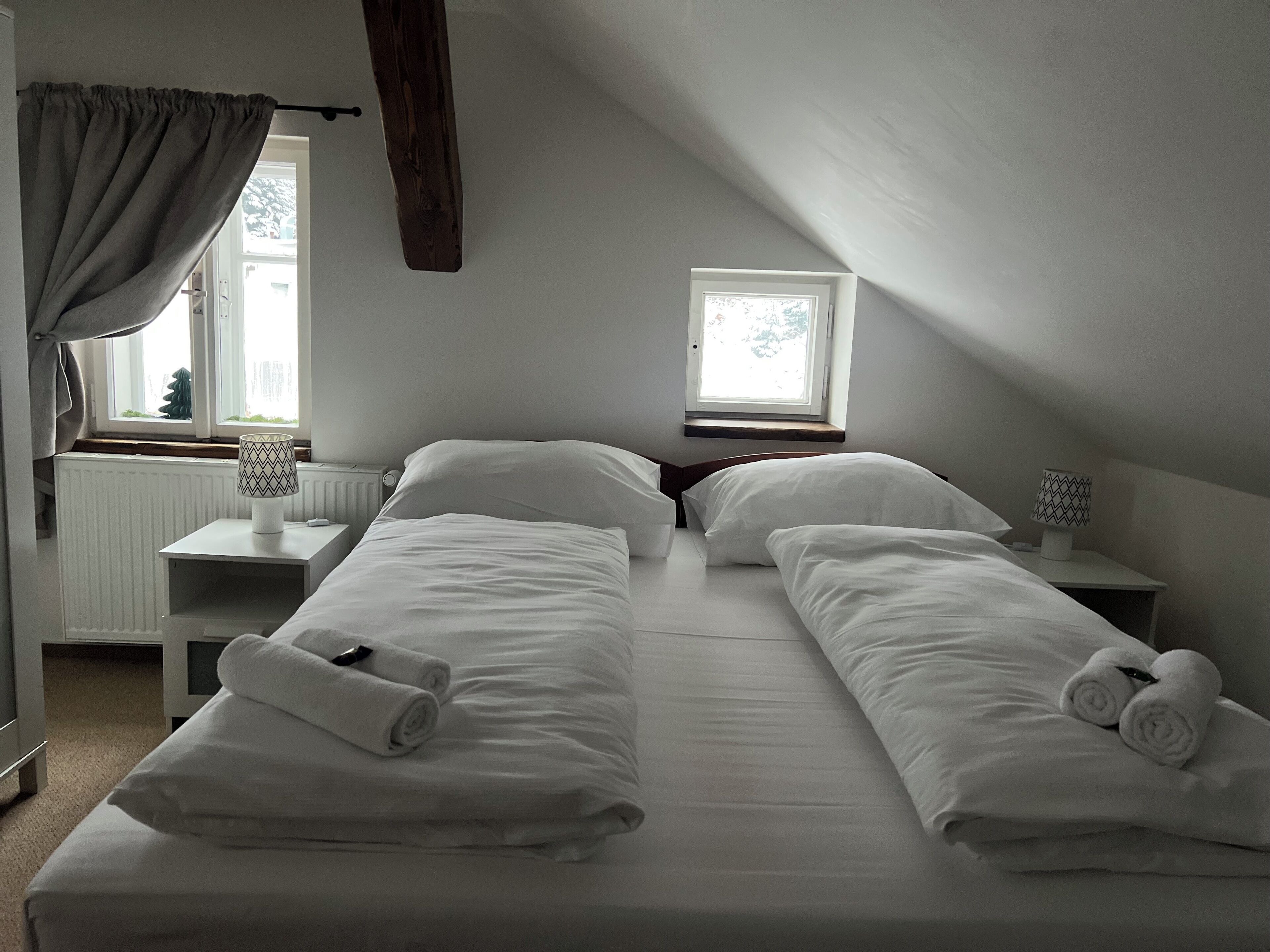 A twin room with two beds, a window, a desk, and a lamp.