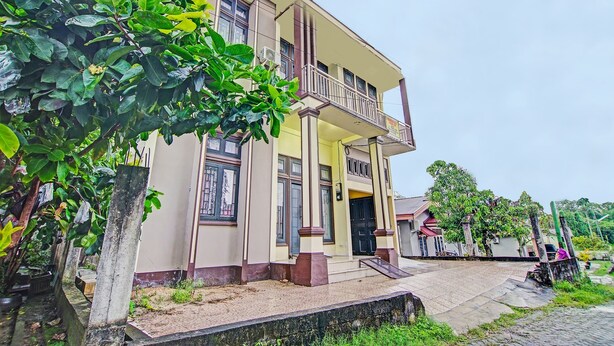 A two-story building with a balcony, a front door, and a small porch area. - Hotel O Arafah Homestay Syariah Near Badan Pertanahan Nasional - Kantor Pertanahan Kabupaten Kampa (Bangkinang)
