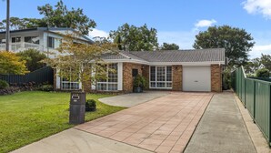 Una casa residencial con garaje, césped cuidado y buzón.