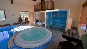 A hot tub with a wooden deck, a balcony, and a view of a pool. - Lakeside Escape, Stone Countryside Cottage (Leek)