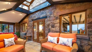 A cozy room with wicker sofas, stone walls, and a skylight. - Lakeside Escape, Stone Countryside Cottage (Leek)