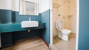 A bathroom with a blue and white color scheme, a sink with a mirror, and a toilet. - The Concept Hotel KL - Batu Caves (Batu Caves)