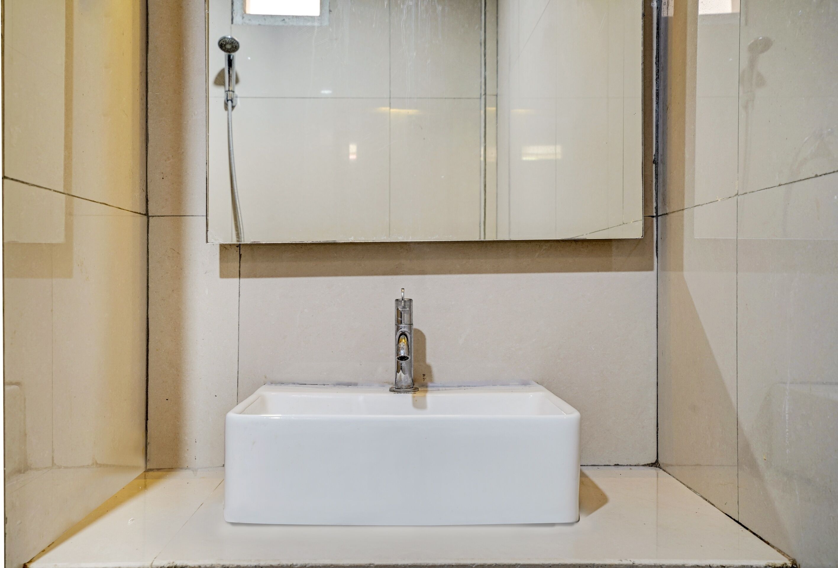 A bathroom with a white sink, a mirror, and a shower.