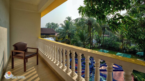 A balcony with a view of a pool and palm trees.