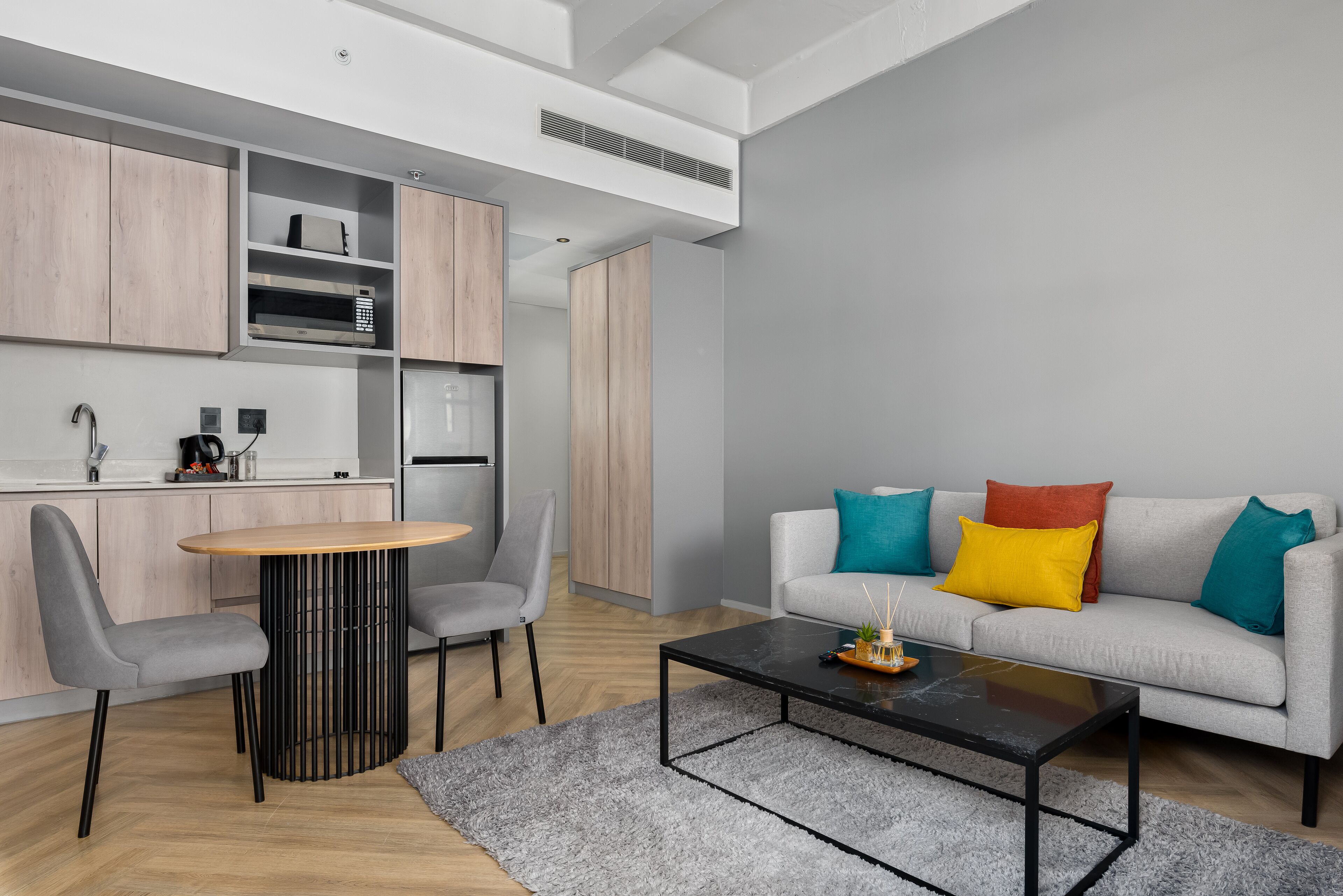 A modern living space with a kitchen, dining area, and seating area.