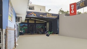 A building with a sign reading "252 Royal Homestay" and a motorcycle parked in front.