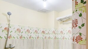 A bathroom with a toilet, shower, and sink.