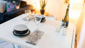 A dining table set with plates, glasses, a bottle, and a candle. - Mary Street Seaside Home in Stonehaven Aberdeenshire (Stonehaven)