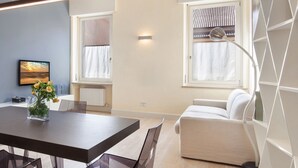 Ein modernes Wohnzimmer mit Esstisch, Sofa und einem großen Fenster mit Blick.