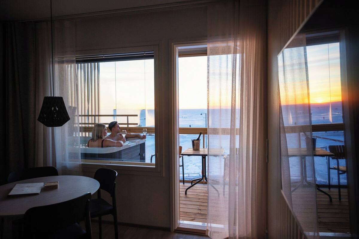 Ein Zimmer mit Meerblick, einem Tisch und Stühlen.