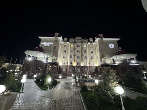 A grand hotel with a symmetrical facade, multiple floors, and a central entrance.