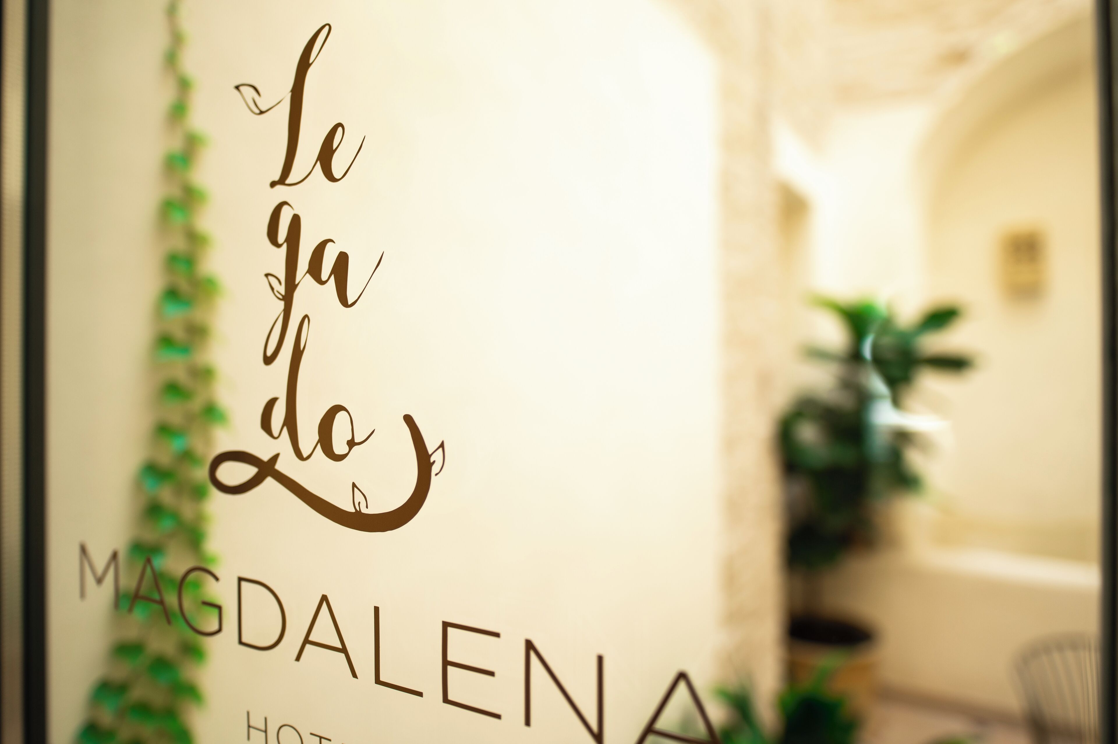 Een bord met de tekst 'le ya do MAGDALENA HOTEL' en een decoratief ontwerp.