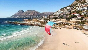 Una playa con vista despejada al océano y una montaña al fondo.