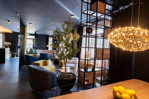 A modern interior with a wooden dining table, a potted plant, and a unique hanging light fixture. - V Business Apartments Böblingen (Boeblingen)