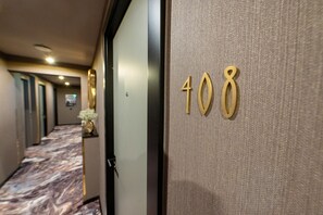A hotel hallway with a marble floor and a door marked with the number 408. - V Business Apartments Böblingen (Boeblingen)
