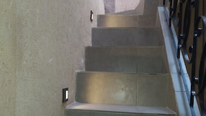 A staircase with concrete steps and metal railings, leading upwards.