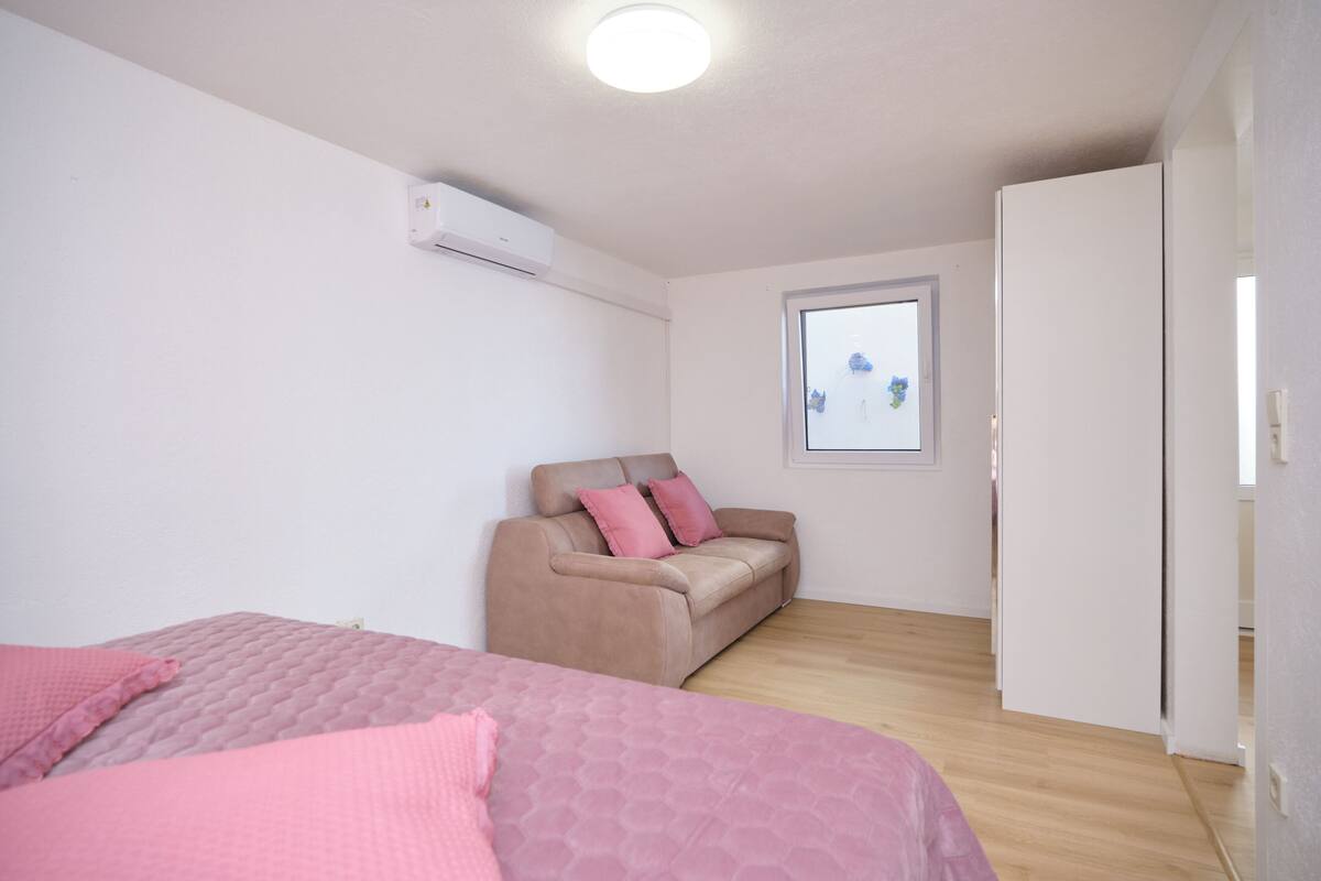 Un dormitorio con cama, sofá y armario.