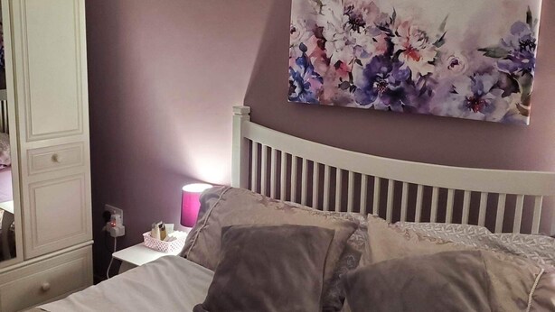 A bedroom with a bed, a nightstand, a lamp, and a wall-mounted painting. - Minimum Stay two Nights (Larne)